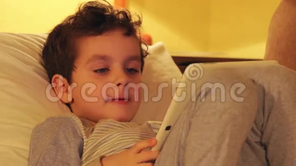 一个可爱的小男孩的肖像家里有一台白色平板电脑视频的预览图