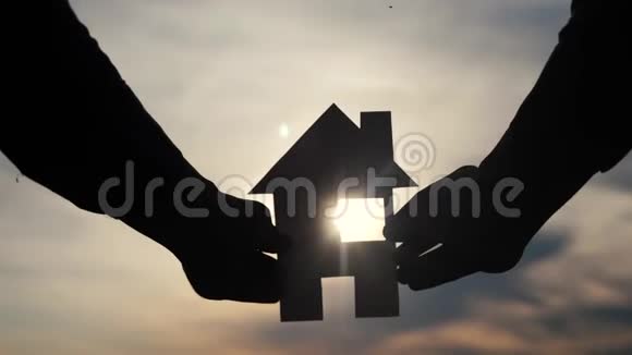 幸福家庭建设住宅理念他手里拿着一个纸房生活方式在夕阳下剪影视频的预览图
