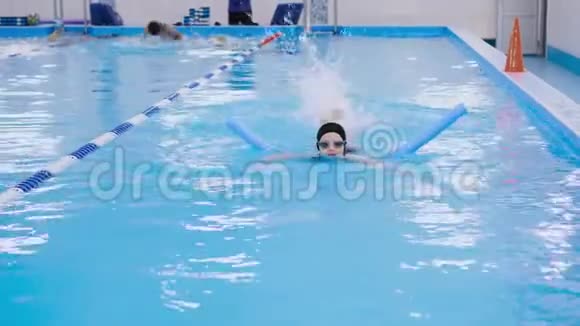 为游泳池里的孩子们上游泳课美丽的皮肤白皙的女孩在水中游泳视频的预览图