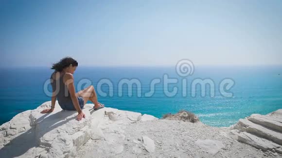 一位年轻女子坐在海边视频的预览图