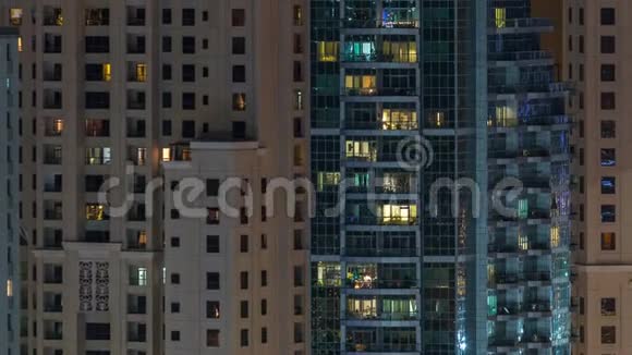 在多层现代玻璃住宅建筑的发光窗口在夜间时间推移点亮视频的预览图