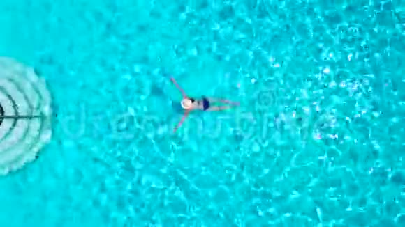 从顶部看一个穿蓝色泳衣的女人在游泳池里游泳视频的预览图
