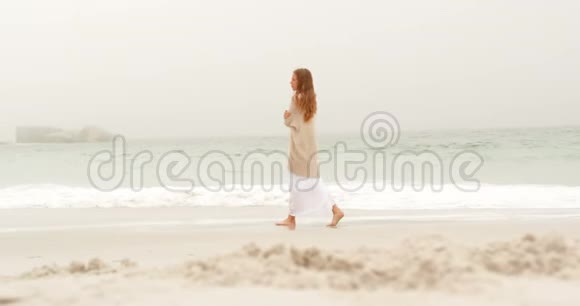 在海滩上行走的白人妇女的侧面景色视频的预览图