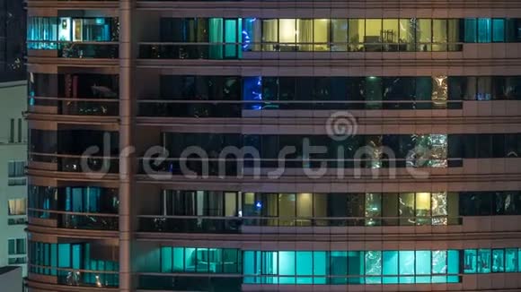 在多层现代玻璃住宅建筑的发光窗口在夜间时间推移点亮视频的预览图