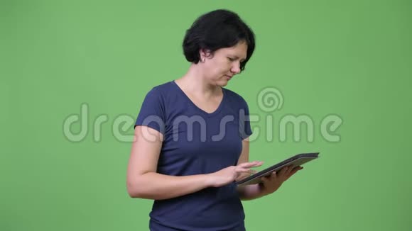 一位留着短发的漂亮女士使用数码平板电脑视频的预览图