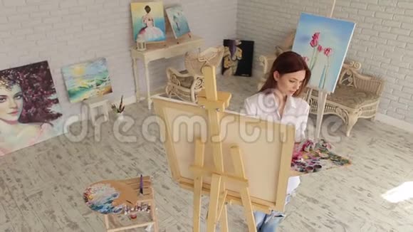 一个年轻的创意女孩在绘画工作室画画视频的预览图