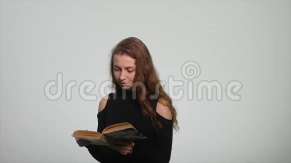 可爱的女孩读一本白色背景的书视频的预览图