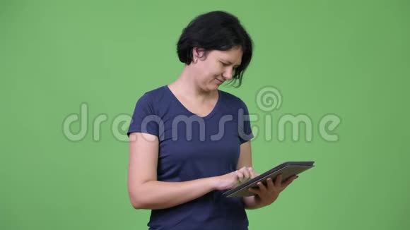 一位留着短发的漂亮女士使用数码平板电脑视频的预览图