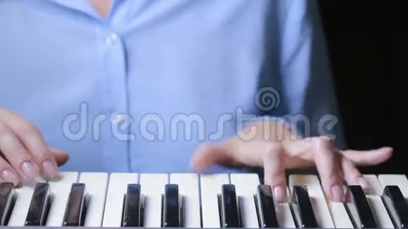 女子手弹奏MIDI控制器键盘合成器特写视频的预览图