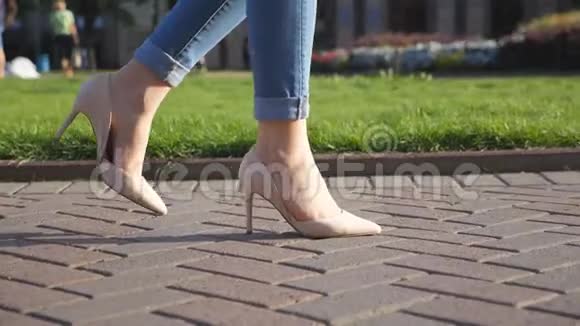 穿高跟鞋的女性腿在城市街道上行走穿着高跟鞋的年轻女人的脚在城里女孩视频的预览图