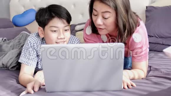 幸福的家庭母子微笑着看着笔记本电脑视频的预览图