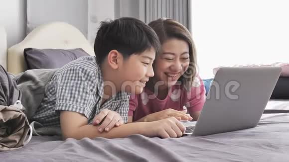 幸福的家庭母子微笑着看着笔记本电脑视频的预览图