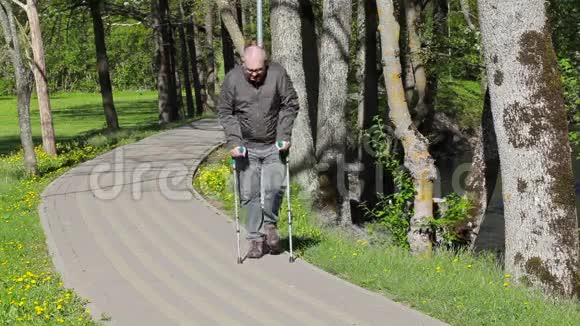 残疾人拄着拐杖在公园的小路上行走视频的预览图