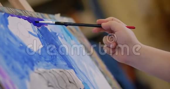 年轻的艺术家的手小女人艺术家用画笔描绘画布坐在桌子上画画布程序视频的预览图
