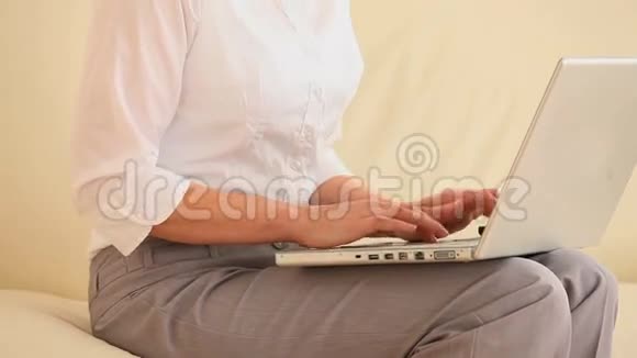 微笑的女人在接电话时用笔记本电脑视频的预览图