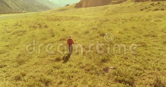 飞行背包徒步旅行游客走过青山野夏日的乡村山谷视频的预览图