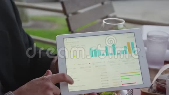 一个人用移动平板电脑在午餐时展示项目视频的预览图