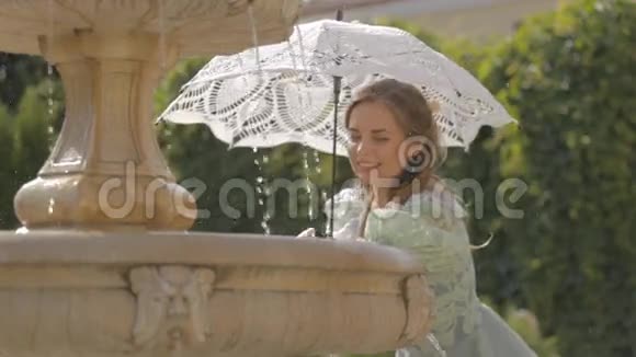 坐在长凳上的带着白色雨伞的女孩视频的预览图