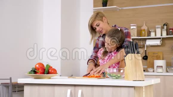 妈妈在厨房帮她的小女儿视频的预览图
