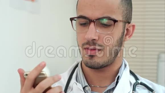 男医生在智能手机上发短信视频的预览图