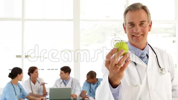 成熟的医生拿着苹果看镜头视频的预览图