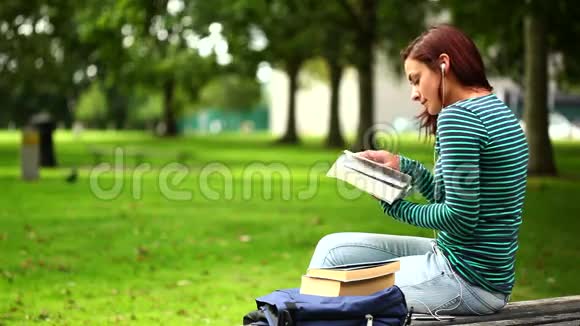 坐在长凳上看书的漂亮学生视频的预览图