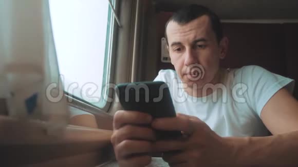 带智能手机的男商人乘火车旅行男人旅行者正在火车上输入一条网络信息视频的预览图