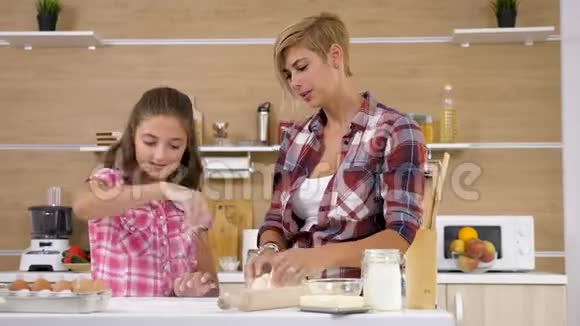 妈妈和小女儿一起在厨房里烤和做饭视频的预览图