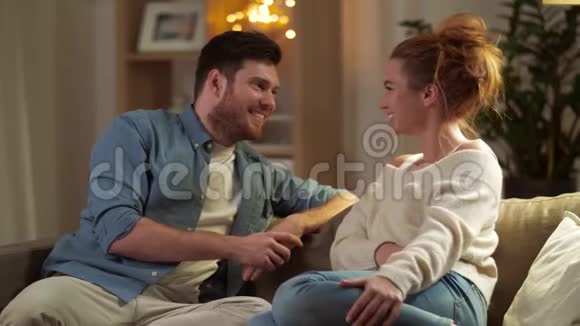 快乐的一对夫妇晚上在家聊天视频的预览图