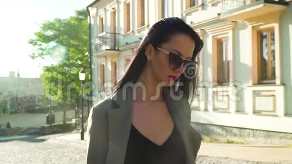 优雅时尚的女士戴着太阳镜慢动作地走在街上视频的预览图
