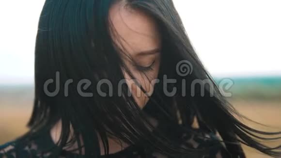漂亮的女孩黑发肖像大唇风发展头发肖像慢动作视频一头深色的女头发视频的预览图