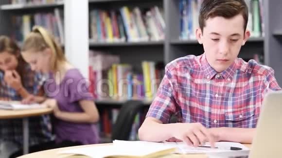 男高中生在笔记本电脑上工作视频的预览图