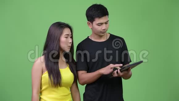 年轻的亚裔夫妇一起使用数码平板电脑视频的预览图