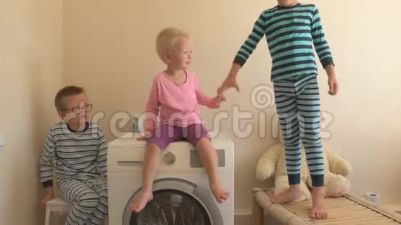父母购买新型号最新一代洗衣机幼儿尝试打开洗软玩具三个快乐的男孩视频的预览图