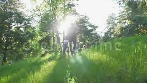 一男一女正和狗在树林里散步视频的预览图