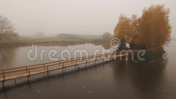 在一个秋天雾蒙的早晨湖中央的童话屋视频的预览图