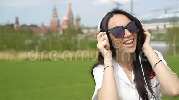 快乐的年轻都市女性享受户外音乐视频的预览图