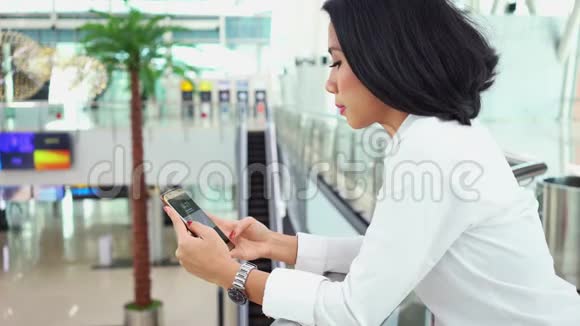 女性在机场候机楼使用手机视频的预览图