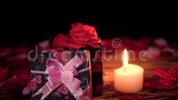 用礼品盒蜡烛和花瓣装饰情人节视频的预览图