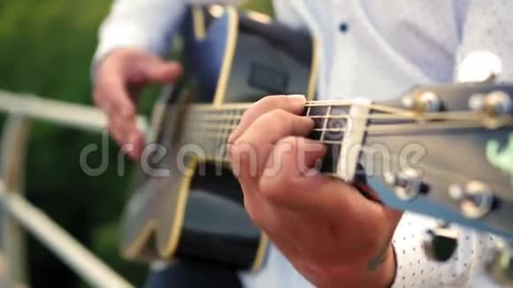 男人弹吉他吉他手在触摸吉他弦近距离射击视频的预览图