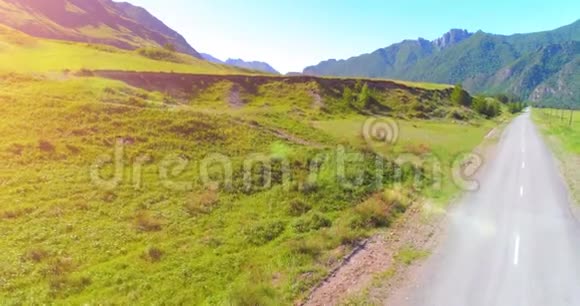 阳光明媚的夏季早晨空中乡村山路和草地沥青公路和河流视频的预览图