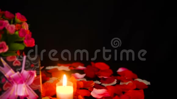 装饰情人节礼物盒蜡烛燃烧和玫瑰花瓣镜头视频的预览图