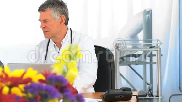 医生带着病人看着笔记本电脑视频的预览图