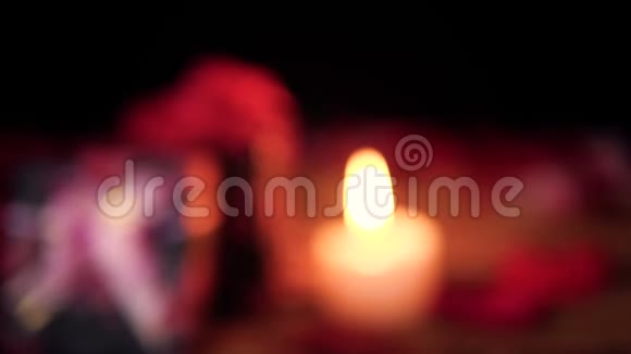 礼品盒花瓣和蜡烛燃烧的视频模糊情人节视频的预览图