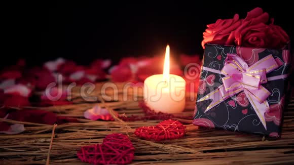 用礼品盒蜡烛和花瓣装饰情人节视频的预览图