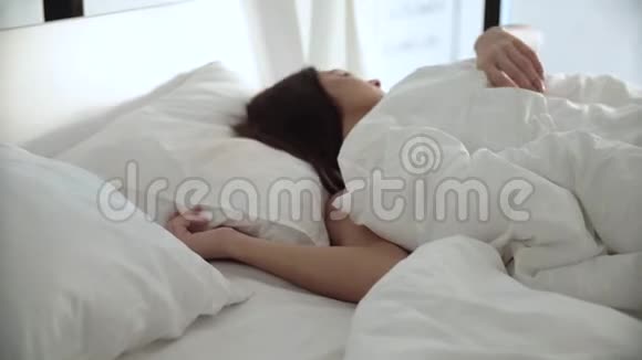 睡觉女人睡在床上在轻卧室有白色被褥视频的预览图