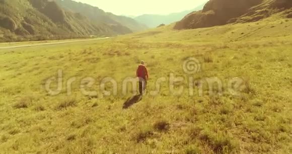 飞行背包徒步旅行游客走过青山野夏日的乡村山谷视频的预览图