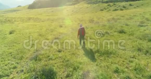 飞行背包徒步旅行游客走过青山野夏日的乡村山谷视频的预览图