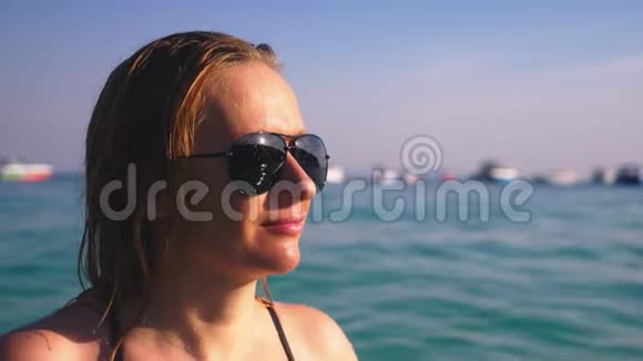 那个女孩穿着黑色泳衣和黑色眼镜的金发女郎有身材的漂亮模特在水晶里玩得很开心视频的预览图