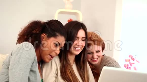 坐在沙发上用笔记本的年轻女性朋友视频的预览图